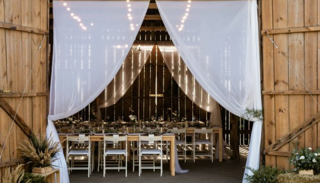 wejście do stodoły weselnej, dekoracja w stylu rustykalnym z tiulem